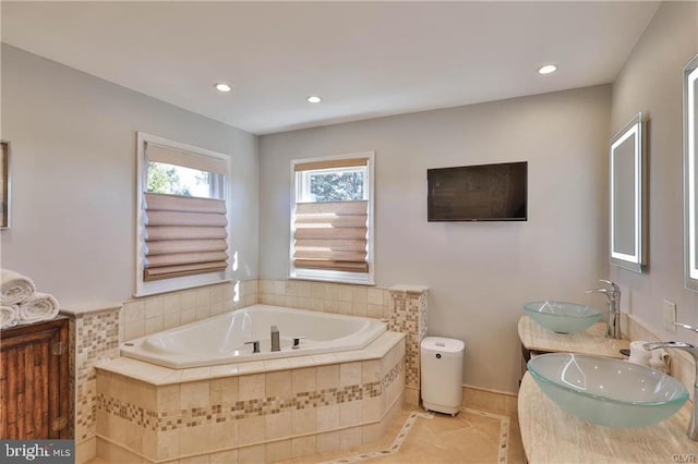 bathroom featuring a sink, a garden tub, double vanity, and recessed lighting