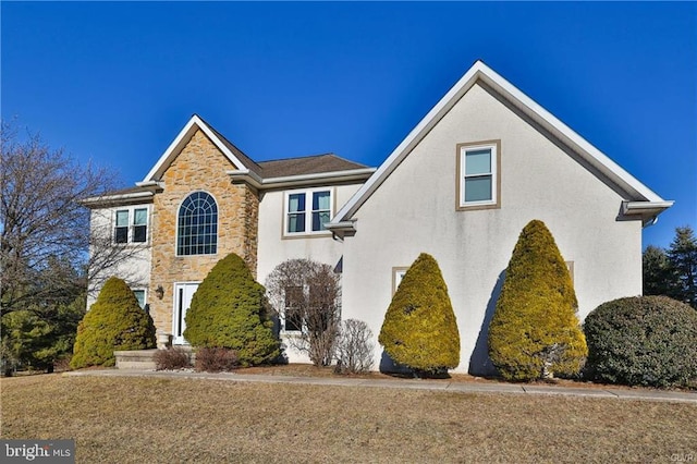 view of front of property featuring stucco siding and stone siding