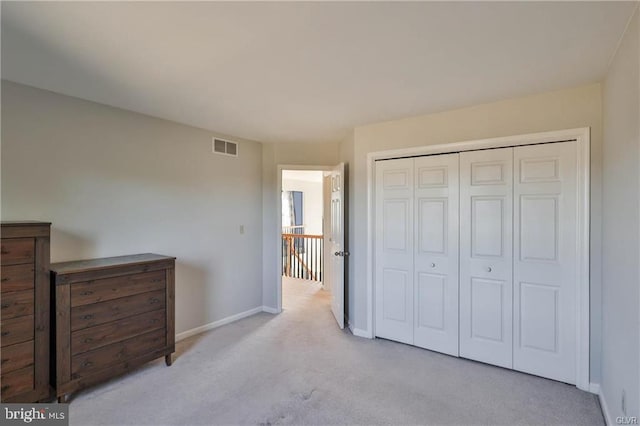 carpeted bedroom with baseboards, visible vents, and a closet