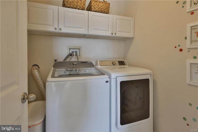 washroom featuring cabinet space and independent washer and dryer