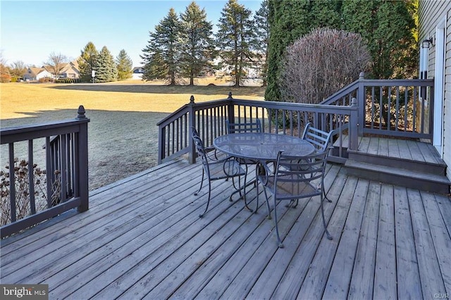 wooden deck with outdoor dining area and a yard