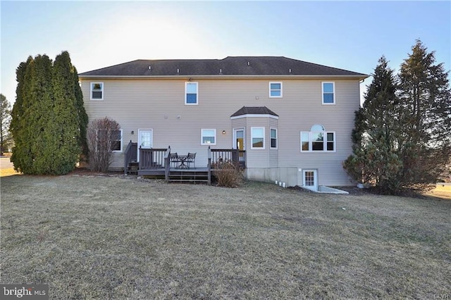 rear view of property with a deck and a lawn