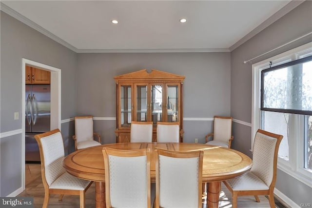 dining room with recessed lighting, wood finished floors, baseboards, and ornamental molding