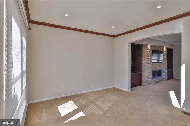 unfurnished living room with crown molding, baseboards, carpet floors, recessed lighting, and a fireplace