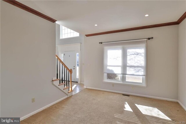 entrance foyer featuring stairway, baseboards, carpet, and ornamental molding