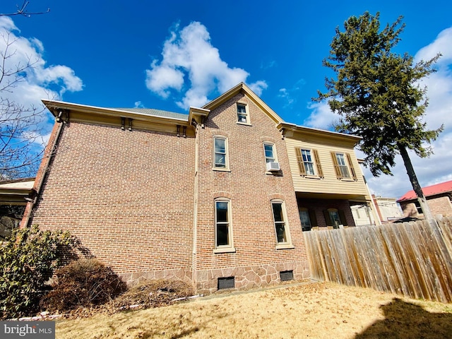 back of property with brick siding and fence