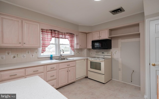 kitchen with white appliances, visible vents, a sink, light countertops, and tasteful backsplash