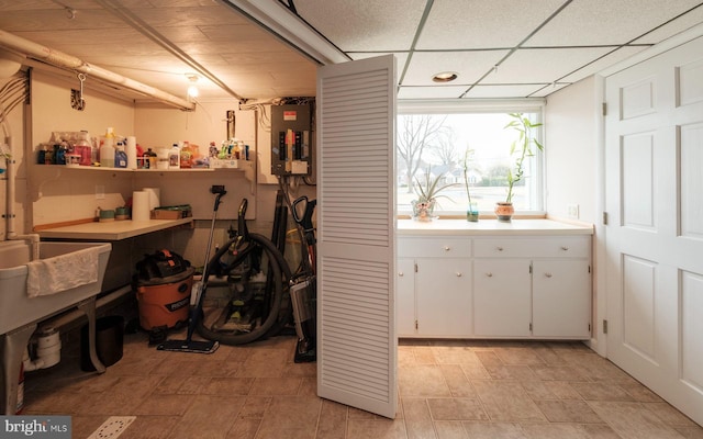 interior space with electric panel and a paneled ceiling