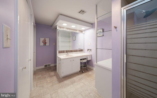 full bath featuring vanity, baseboards, and visible vents