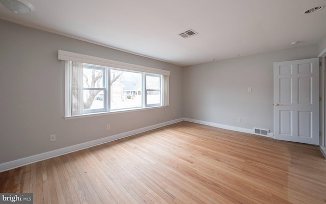 empty room with visible vents, baseboards, and light wood finished floors