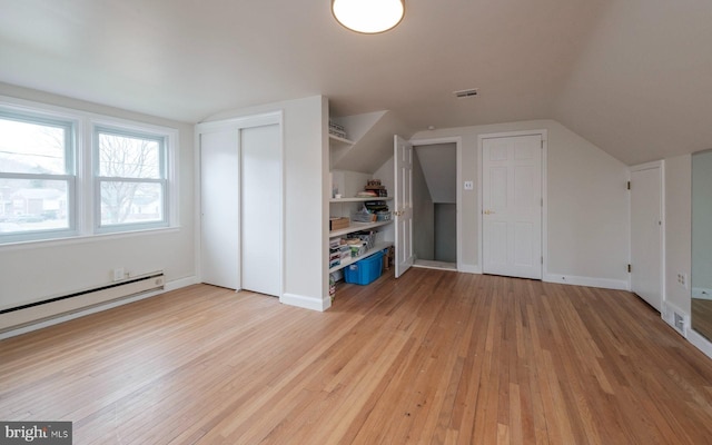 bonus room featuring light wood-type flooring, visible vents, baseboards, baseboard heating, and vaulted ceiling