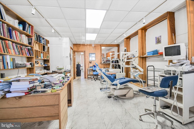 office area featuring a drop ceiling, marble finish floor, and track lighting