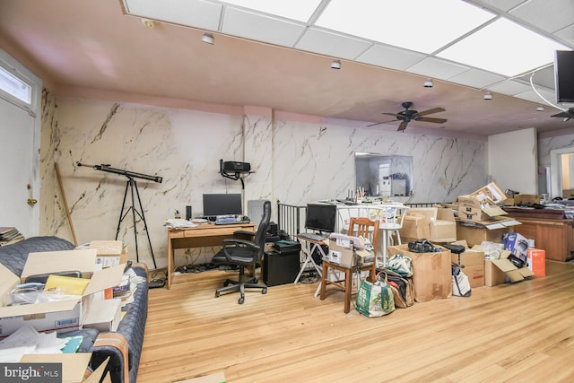 office with ceiling fan, a drop ceiling, and wood finished floors