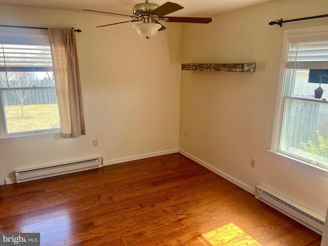 empty room featuring a baseboard heating unit, baseboards, baseboard heating, wood finished floors, and a ceiling fan