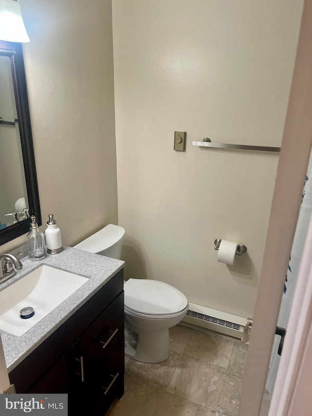 bathroom featuring toilet, vanity, and a baseboard radiator