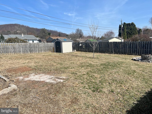 view of yard with a storage unit, a fenced backyard, and an outdoor structure