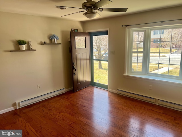 interior space with baseboards, baseboard heating, and wood finished floors