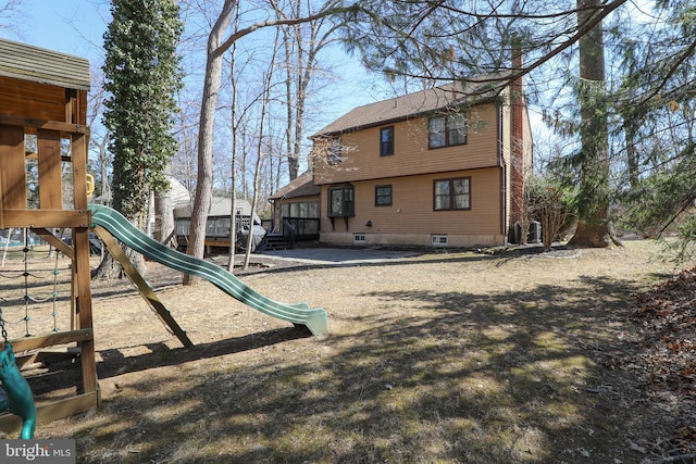 rear view of house featuring a playground