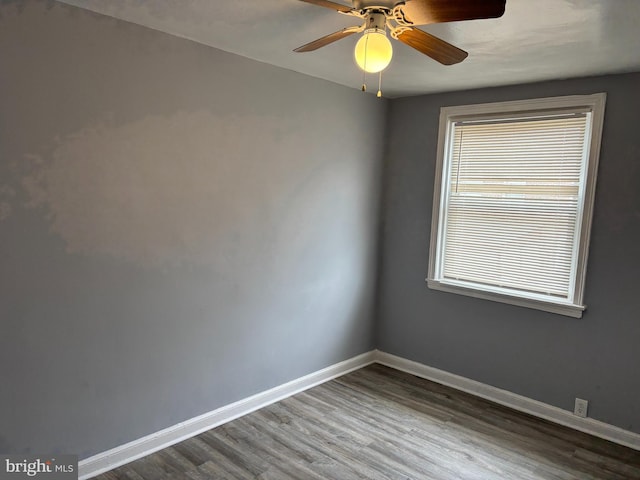 spare room featuring ceiling fan, baseboards, and wood finished floors