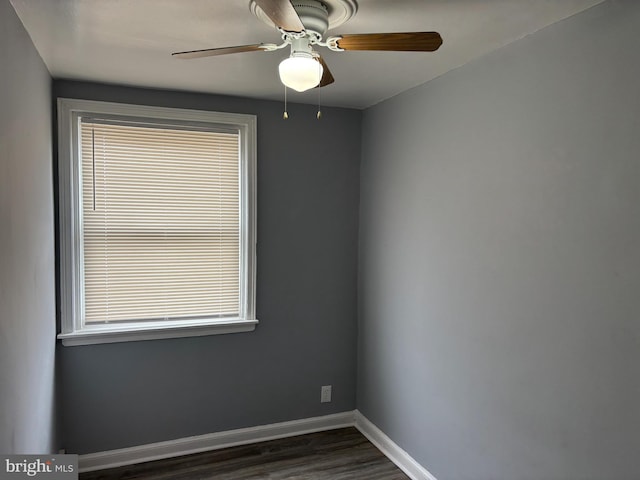 unfurnished room with baseboards, dark wood-style flooring, and ceiling fan