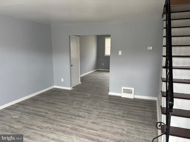 unfurnished room featuring visible vents, baseboards, and wood finished floors