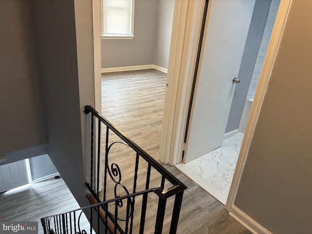 staircase featuring baseboards and wood finished floors