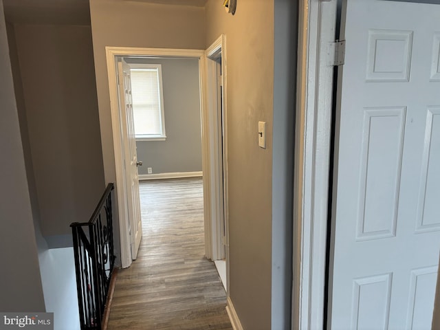 hallway featuring wood finished floors and baseboards