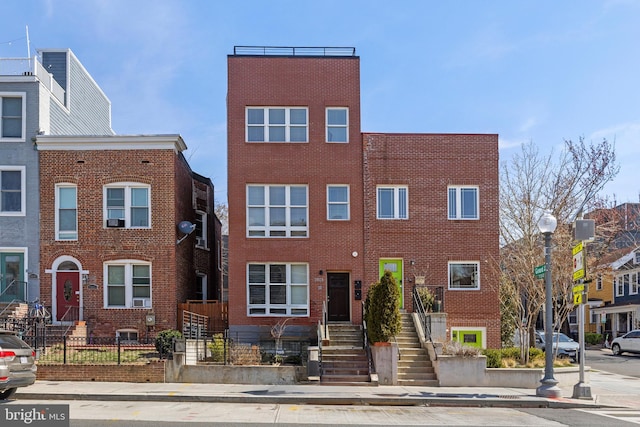 townhome / multi-family property with brick siding and a fenced front yard