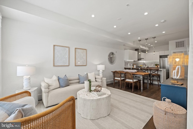 living room with recessed lighting, visible vents, and dark wood-style flooring