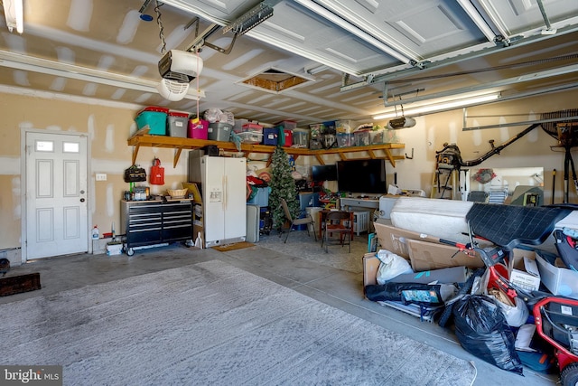 1107 Liberty Ave, Vineland, NJ 08360 - garage with a workshop area, a garage door opener, and white fridge with ice dispenser