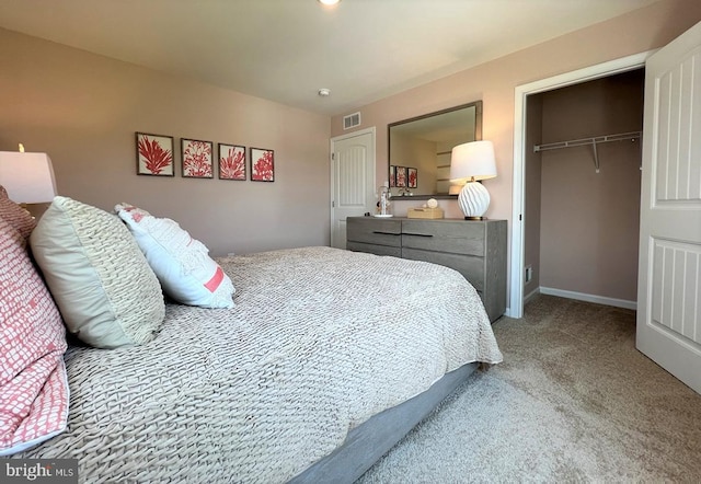 bedroom with visible vents, carpet floors, baseboards, a closet, and a walk in closet