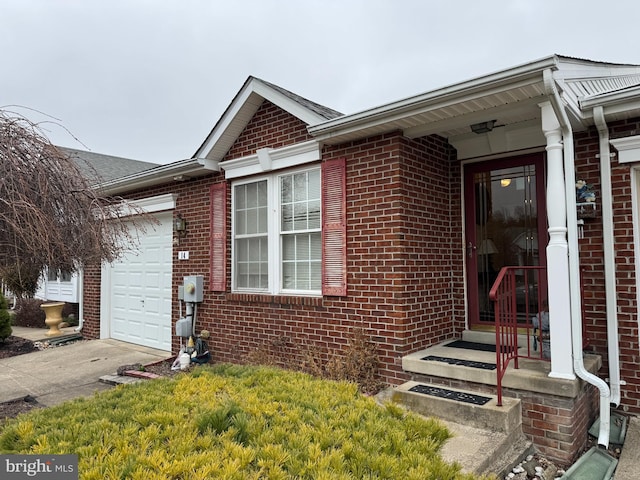 view of front of property with a garage, brick siding, and concrete driveway