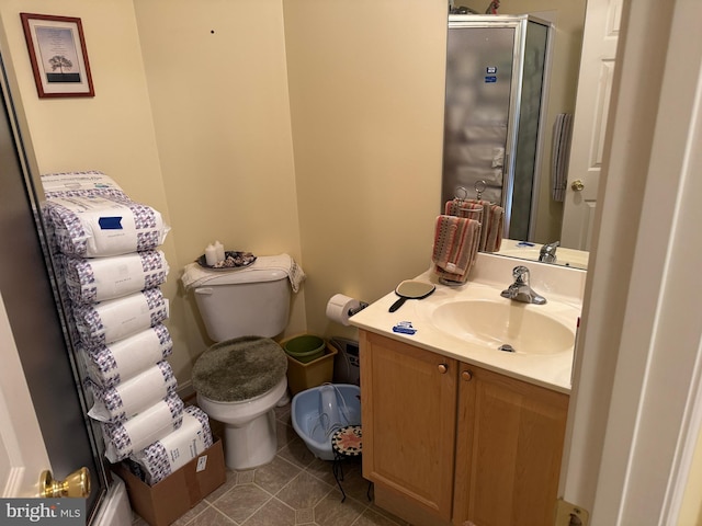 bathroom with tile patterned flooring, toilet, a stall shower, and vanity