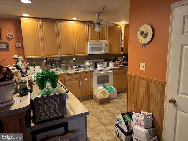 kitchen with a ceiling fan, recessed lighting, white appliances, wainscoting, and light countertops