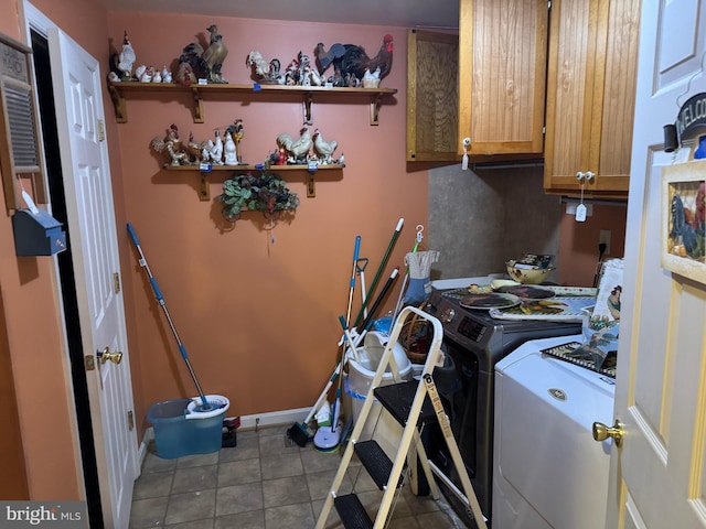 laundry room with tile patterned floors, cabinet space, and washer and clothes dryer