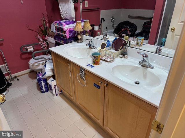 full bath with tile patterned flooring, double vanity, toilet, and a sink