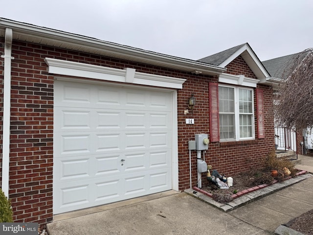 exterior space with a garage, brick siding, and driveway