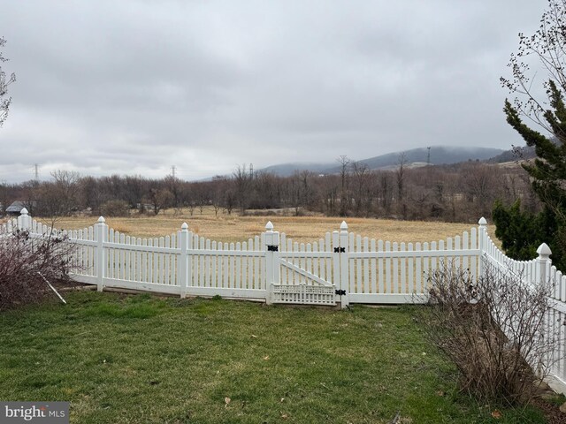 view of yard with a rural view, a gate, and fence