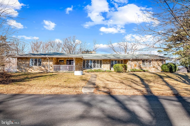 view of front of home featuring stone siding, a porch, and a front yard