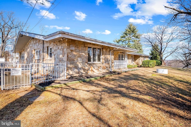 view of property exterior with a yard, stone siding, and fence