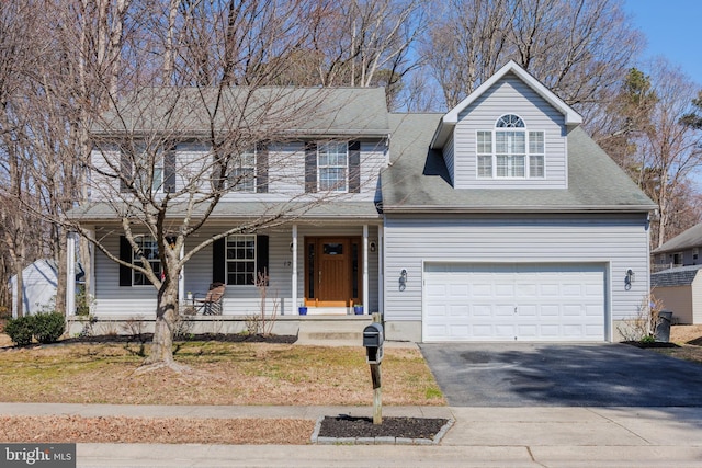 traditional home featuring aphalt driveway, a porch, and a garage