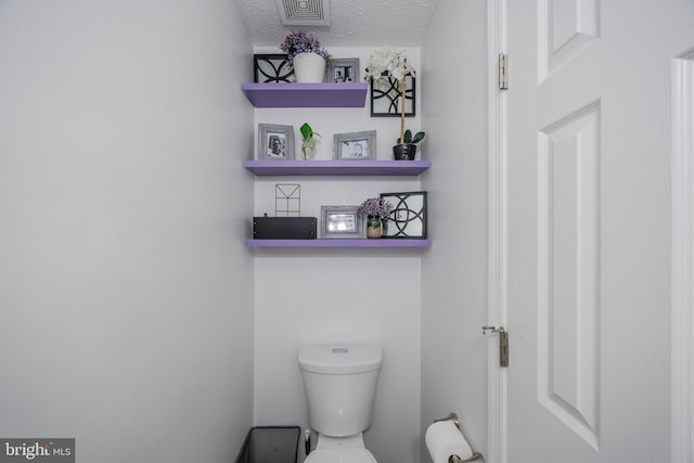 bathroom with visible vents, a textured ceiling, and toilet