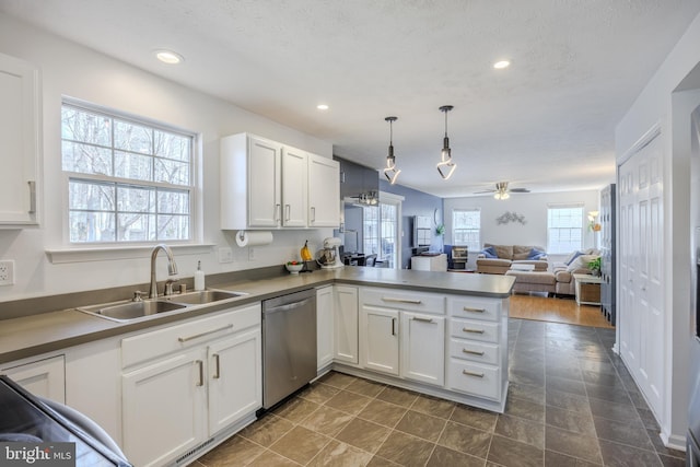 kitchen with ceiling fan, dishwasher, a peninsula, white cabinetry, and a sink