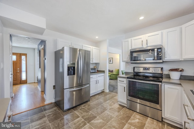 kitchen with recessed lighting, appliances with stainless steel finishes, and white cabinetry