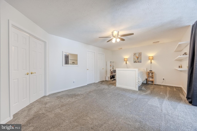 unfurnished bedroom with baseboards, carpet, ceiling fan, and a textured ceiling