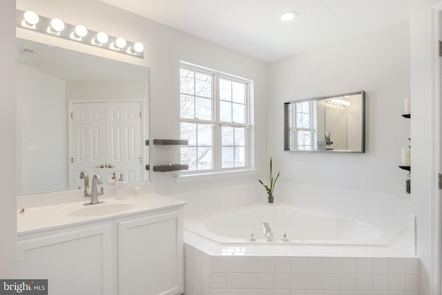 full bathroom with recessed lighting, vanity, and a garden tub