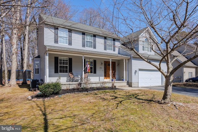 traditional-style house featuring a front lawn, aphalt driveway, a trampoline, a porch, and central AC