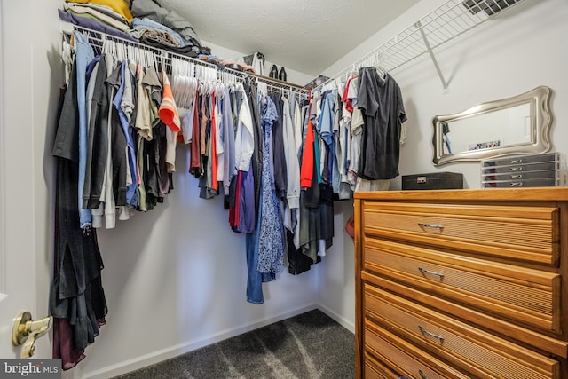 walk in closet with visible vents and dark carpet