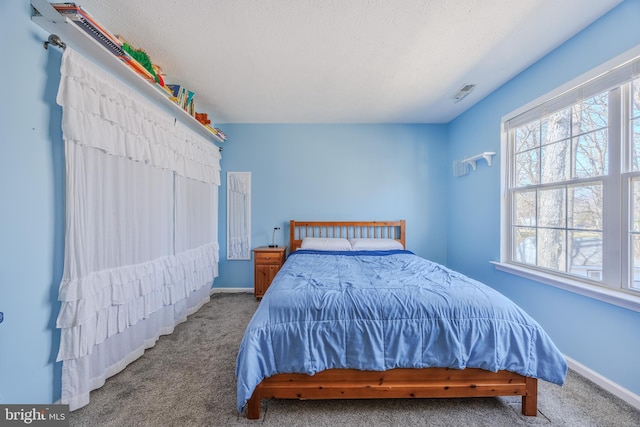 bedroom featuring visible vents, a textured ceiling, baseboards, and carpet floors