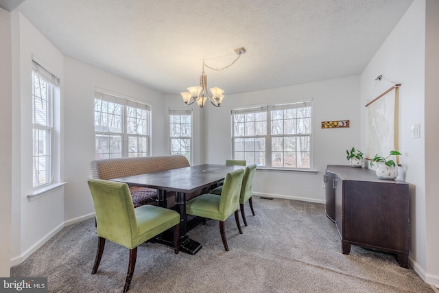 carpeted dining area with baseboards, visible vents, a textured ceiling, and an inviting chandelier